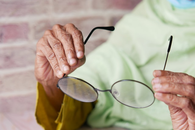 Someone holding up a pair of glasses